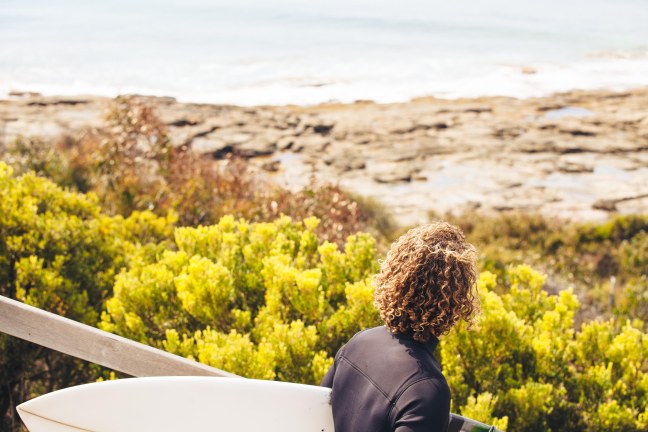This photo shows a surfer heading out to the beach