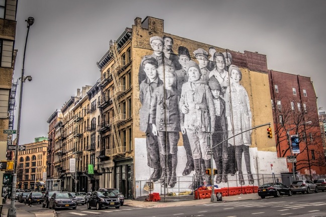 This photo shows a New York City billboard of Ellis Island children covering the side of a building