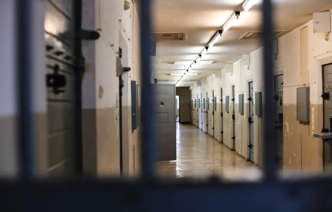 A view of a prison hallway seen through steel bars