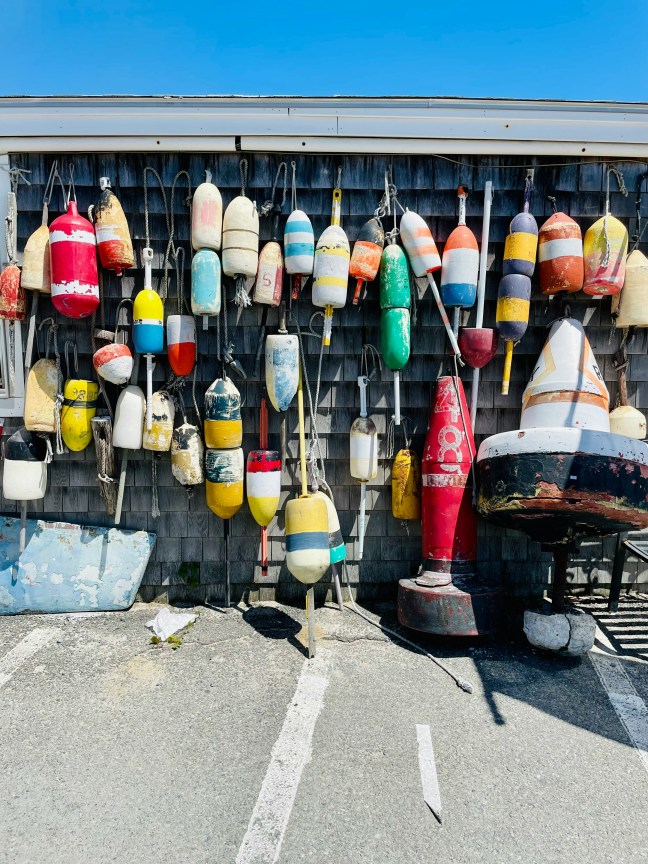 This photo shows colorful buoys side by side on a waterfront shack on the U.S. Atlantic Coast